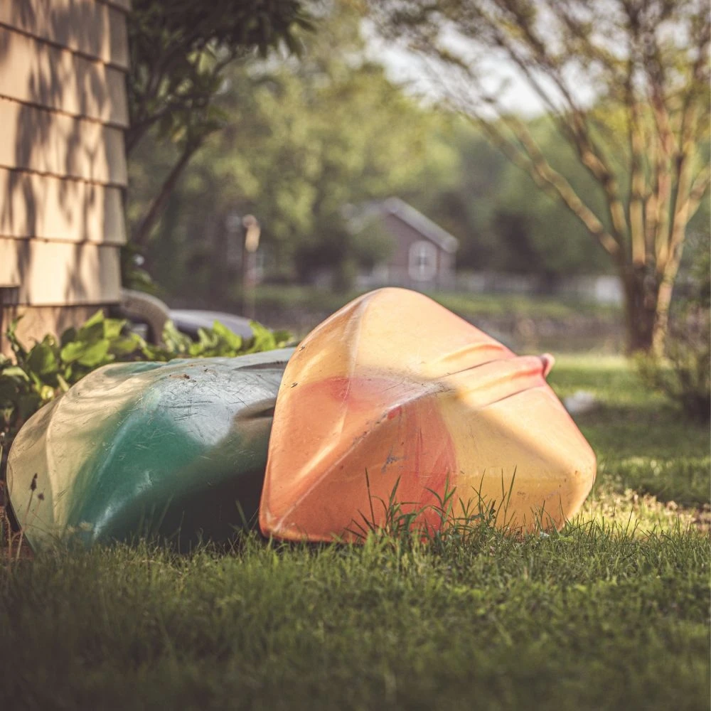 Colorful kayaks and canoes resting on the grass at Chesapeake Paradise, ready for guests to enjoy the waterfront.