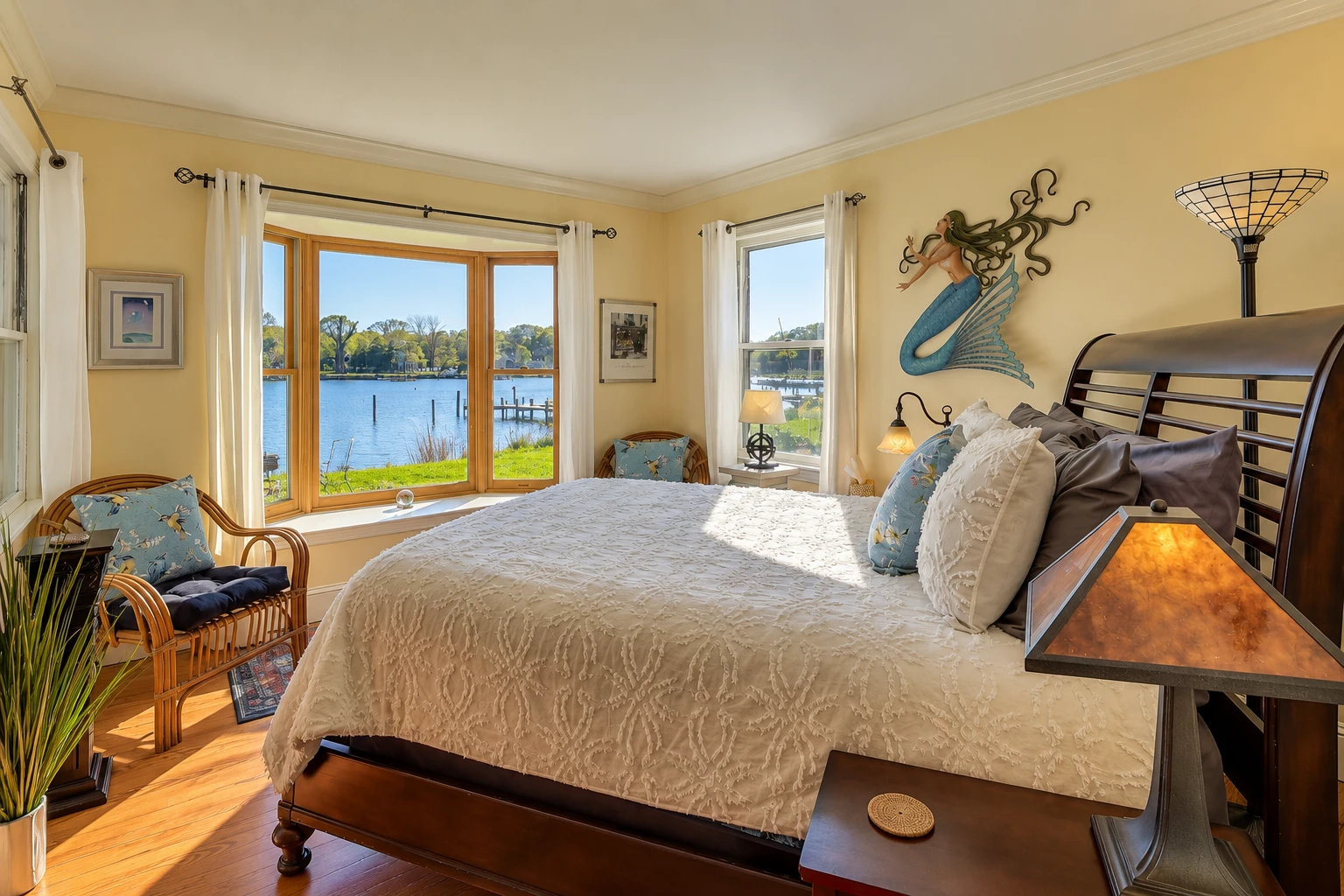Bright bedroom in the Waterfront Wonder Cottage at Chesapeake Paradise with a king bed, large bay window, and peaceful water views.