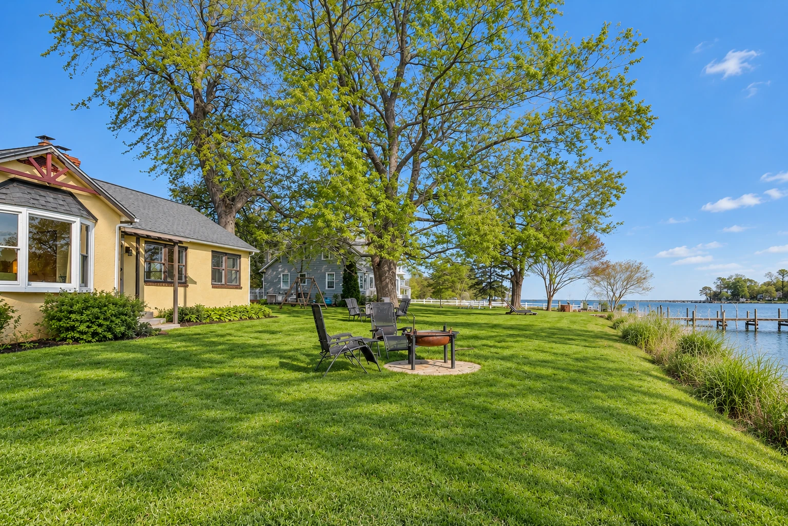 Waterfront Wonder Cottage at Chesapeake Paradise with a spacious lawn, outdoor fire pit, mature shade trees, and peaceful waterfront views.